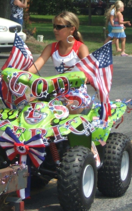 A young lady rides a decorated ATV in the Allen July 4th parade.
